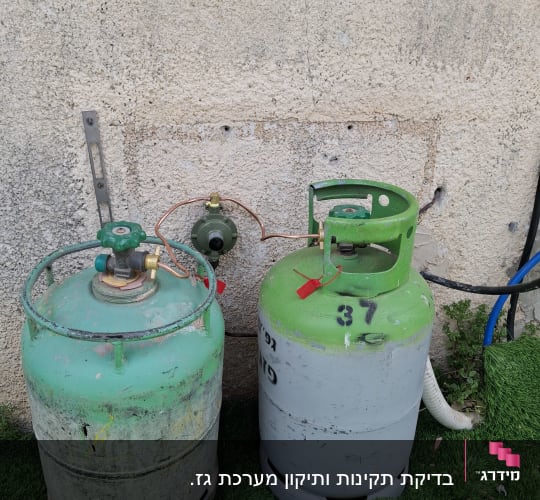 שני בלוני גז ירוקים מחוברים לקיר